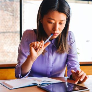 woman reading and looking at a tablet